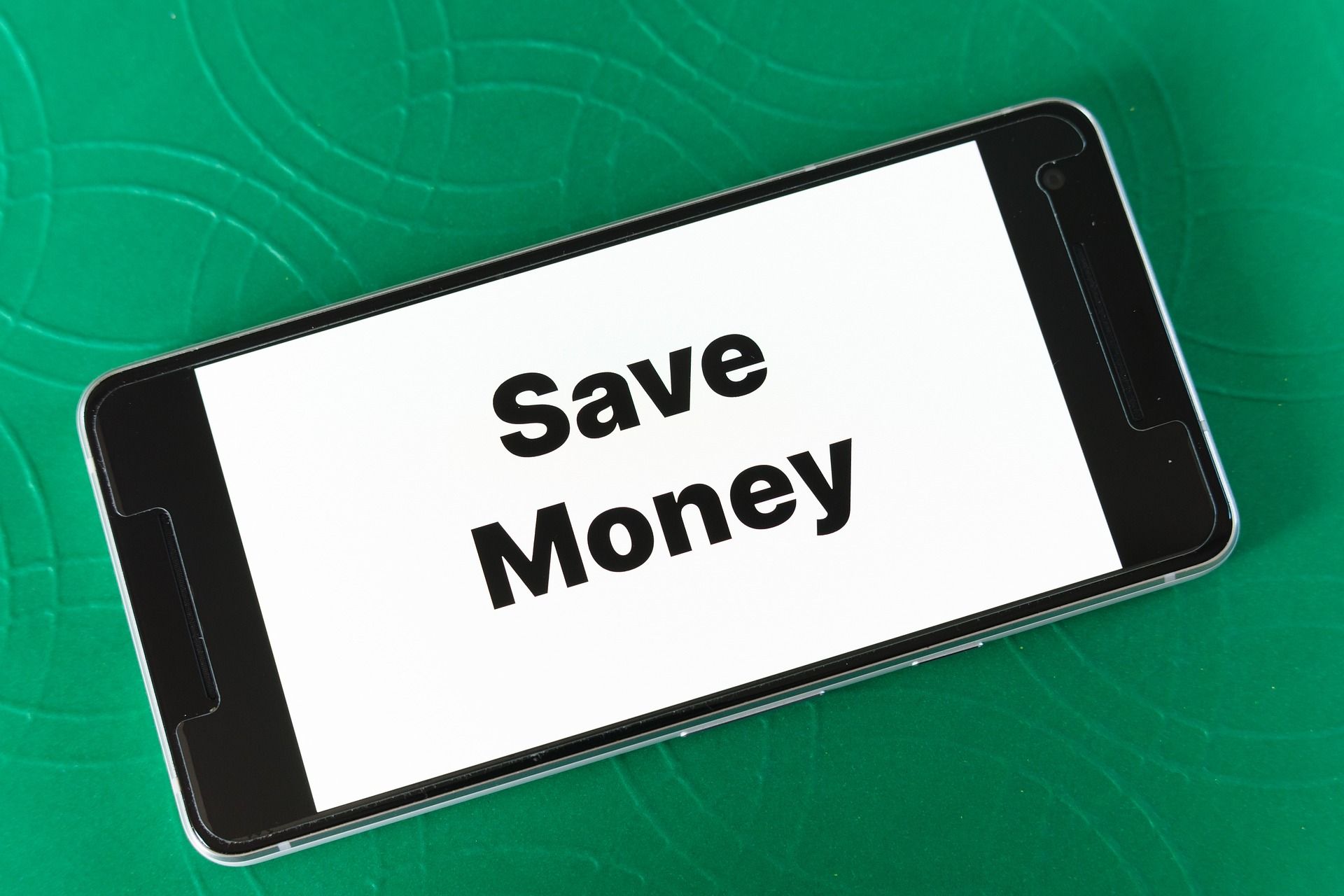綠色背景上顯示 Save Money 的手機畫面，代表選擇香港加密貨幣卡時節省手續費